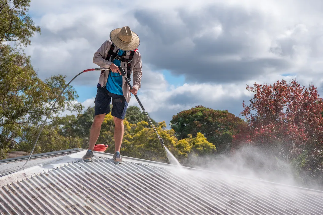 Kleen Genie technician pressure washing & cleaning residential metal roof