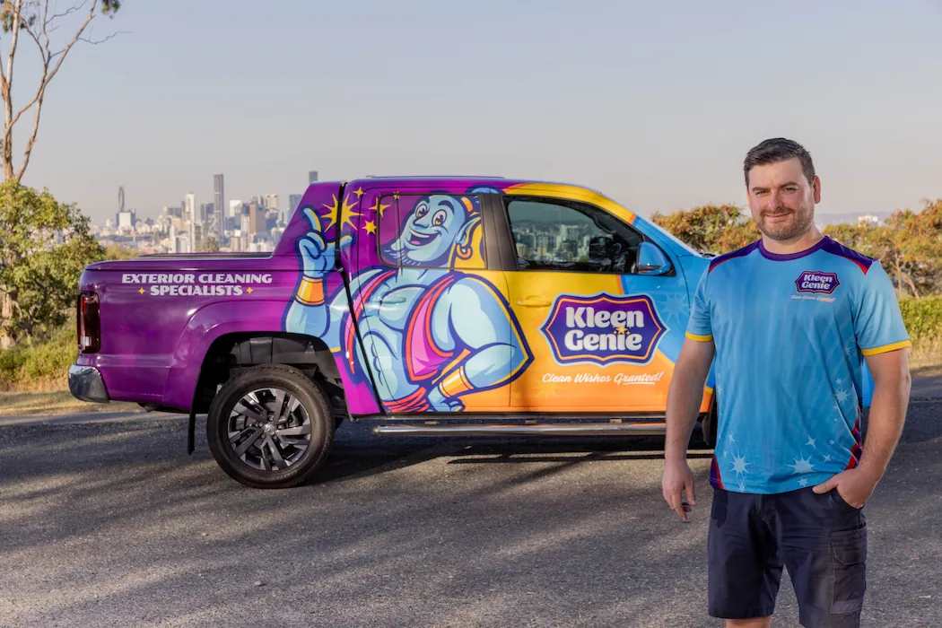 kg-team-3 Kleen Genie owner standing in front of branded vehicle with Brisbane city on the horizon