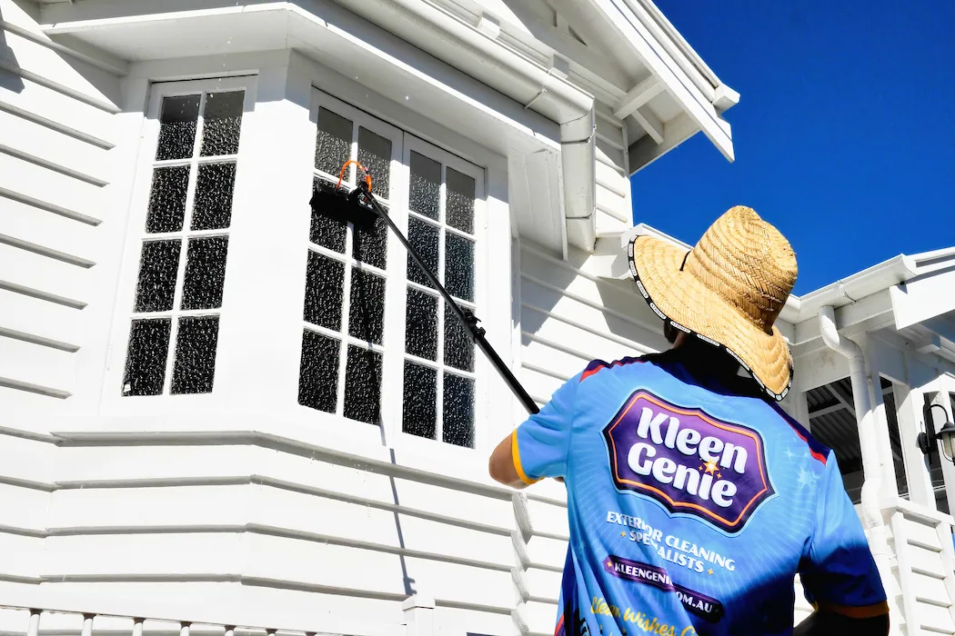 kg-window-cleaning-1 Kleen Genie technician using window cleaning equipment on external window of Australian style house